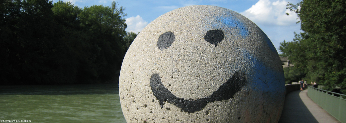 Smiley auf großer Steinkugel